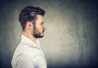 Beyaz gömlek gri arka plan üzerinde ciddi seyir yetişkin modern insan yan görünüm