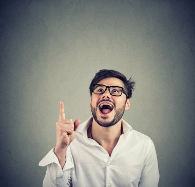 Beyaz gömlek ve gri arka plan üzerinde yukarıyı gözlük parlak mutlu adam