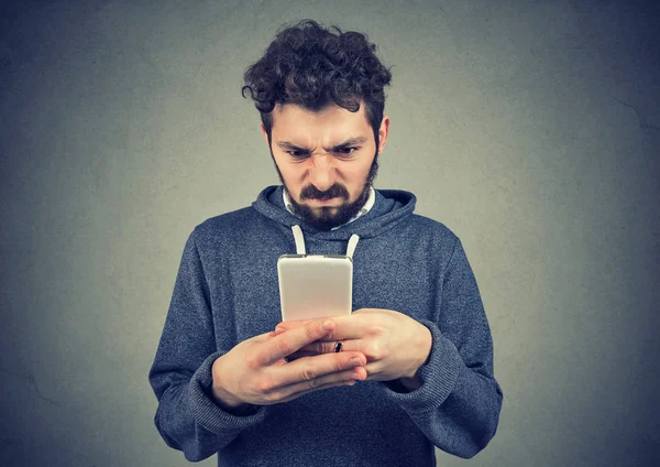 Genç adam akıllı telefon kısa mesaj ile üzgün olmanın tutan sakallı 
