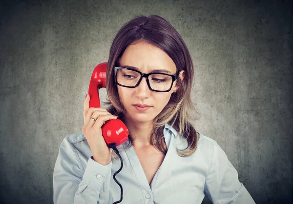 Young Frowning Woman Having Problem While Speaking Red Telephone Gray — Stock Photo, Image