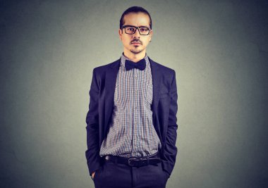 Şık takım elbise ve ceplerinde elele ve kameraya bakarak gözlük yakışıklı genç 