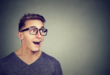 Şaşırmış adam uzakta gri arka plan üzerinde seyir hayran