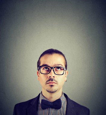 Yetişkin sakallı adam gri arka plan üzerinde düşünürken seyir gözlük