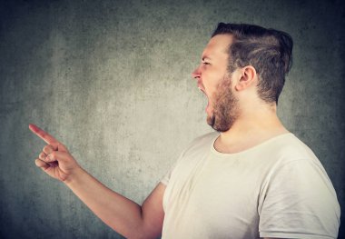 Öfkeyle bağırıyor ve biri gri arka plan üzerinde parmak işaret genç casual tombul adam