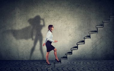 Süper kahraman iş kadını merdivenlerde başarı için gri duvar arka plan üzerinde tırmanma hızlandırılması
