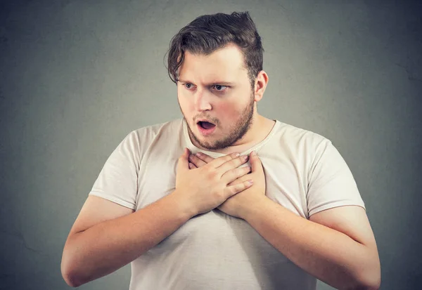 成人の肥満男性呼吸にできない胸に手を繋いでいると灰色の背景に重点を置かれています — ストック写真