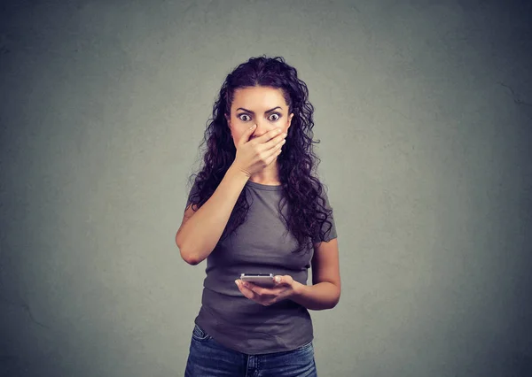 Молода Брюнетка Прикриває Рот Подивом Тримаючи Телефон Читаючи Шокуючі Новини — стокове фото