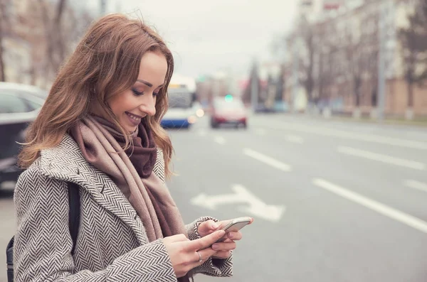 Gülümseyen Casual Kadın Bir Otobüs Beklerken Cep Telefonu Üzerinden Posta — Stok fotoğraf