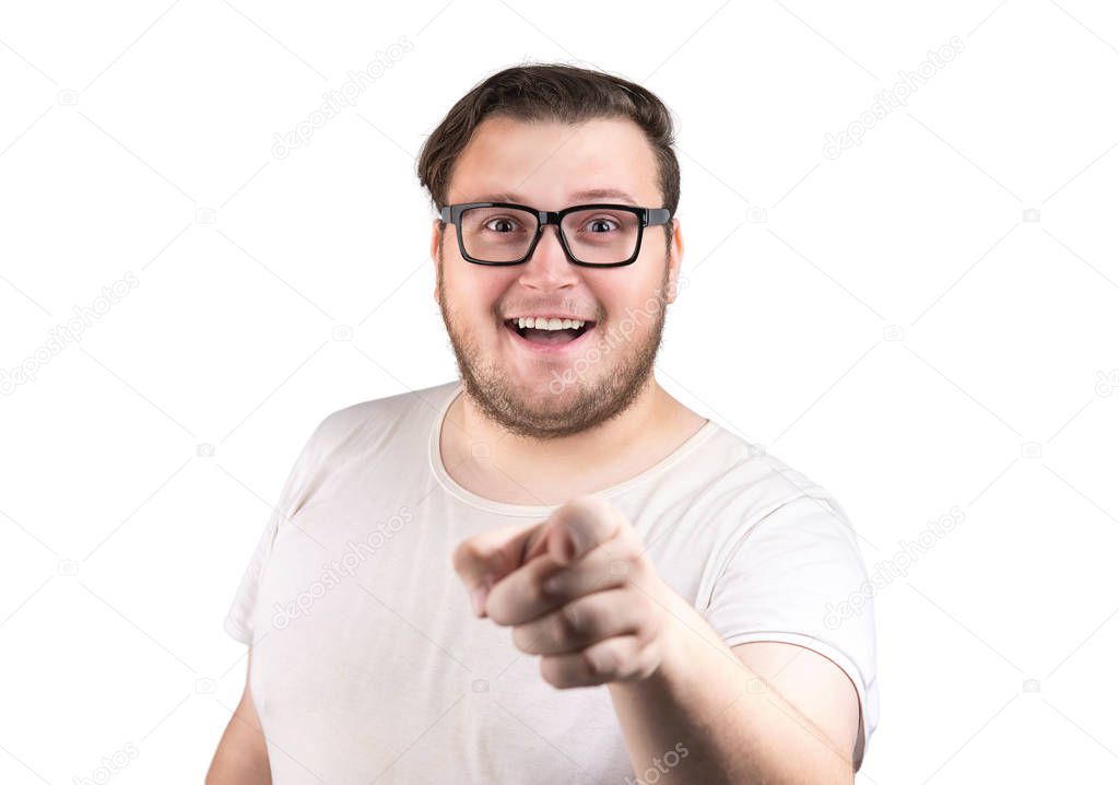 Cheerful chubby man in white t-shirt and glasses smiling and pointing at camera isolated on white background