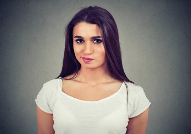 Gri arka plan üzerinde izole bir genç casual kadın ayakta bakarak portre memnun