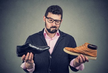 Genç adam bir ayakkabı seçim yapma 