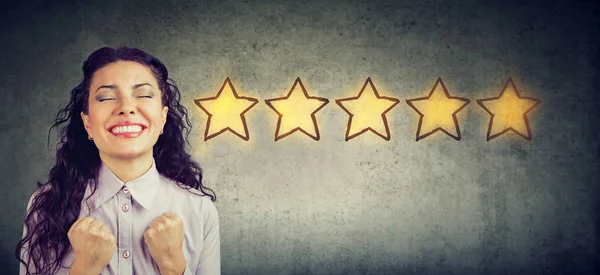 Cheerful beautiful woman smiling celebrating five stars rating for service provided. — Stock Photo, Image