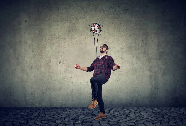 Volle Länge eines jungen Mannes, der mit einem Fußball jongliert — Stockfoto
