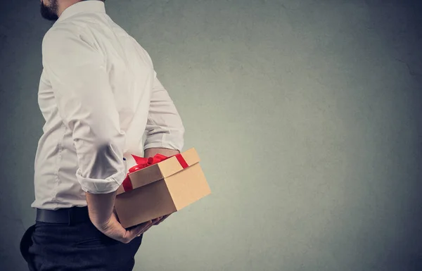 Primer plano de un hombre con camisa blanca sosteniendo una caja de regalo a sus espaldas — Foto de Stock
