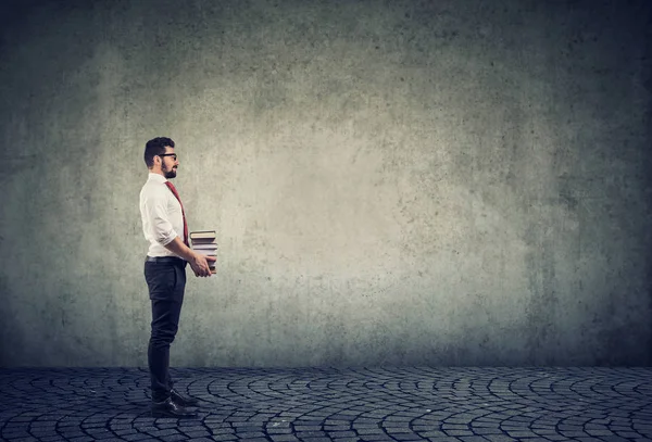 Smart man holding pile of books isolated on gray wall background. — Stock Photo, Image