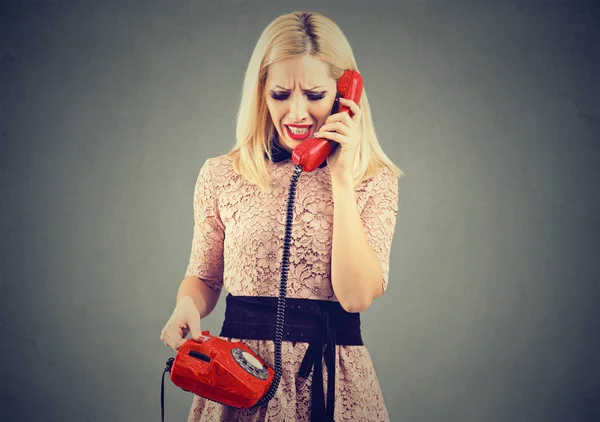 Wütende blonde Frau erhält schlechte Nachrichten am Telefon — Stockfoto