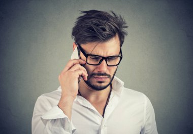 Cep telefonundan aşağı bakan üzgün ifade ile işadamı 