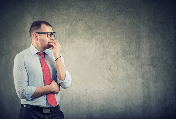 Business man in glasses biting nails being in panic and anxiety looking to the side — Stock Photo, Image