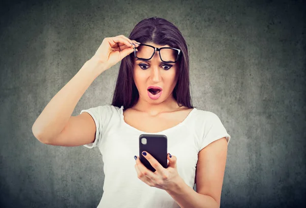 Portret van een geschokt jong meisje kijken naar mobiele telefoon — Stockfoto