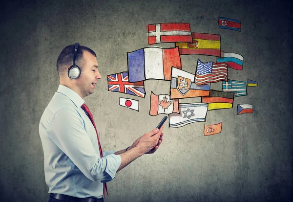 Young man in headphones learning different languages — Stock Photo, Image
