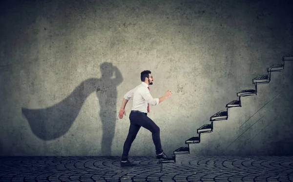 Hombre de negocios súper héroe subiendo escaleras al éxito — Foto de Stock