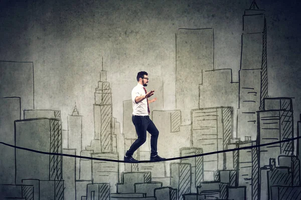 Επιχειρηματίας που περπατάει ισορροπώντας σε ένα σχοινί πάνω από μια πόλη — Φωτογραφία Αρχείου