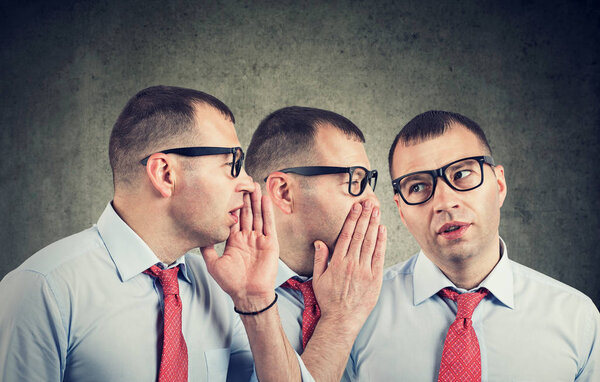 young businessman self whispering in the ear.