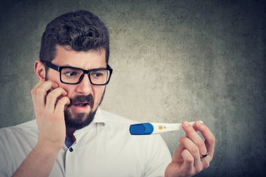 endişeli adam pozitif bir laboratuvar test sonucu bakarak 