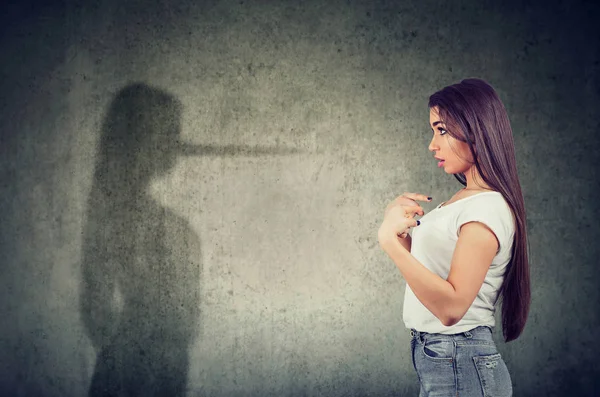 Woman pointing at herself looking at a shadow with long nose of a liar. — Stock Photo, Image