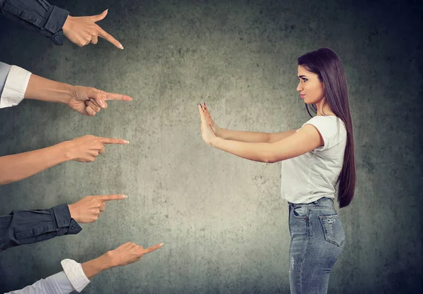 Mujer defendiéndose de culpar a la gente señalándola con los dedos — Foto de Stock