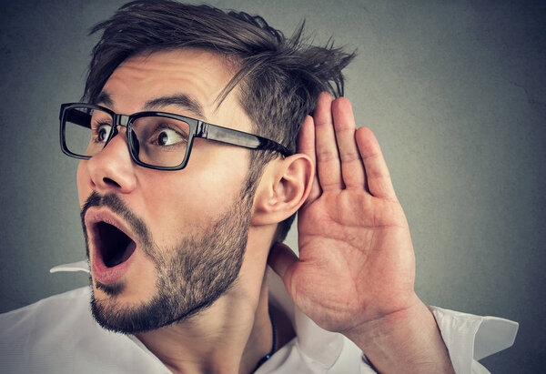 шокированный смешной мужчина тайно подслушивает приватный разговор
