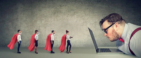 Stressed business man being helped online by professional team of super hero people — Stockfoto