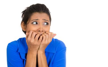 Tırnaklarını yiyen genç bir kadının portresi. Endişeli görünüyor. Beyaz arka planda yalnız.. 