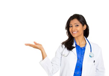 Portrait of a friendly smiling confident female, healthcare professional with lab coat, a doctor pointing at blank copy space  clipart
