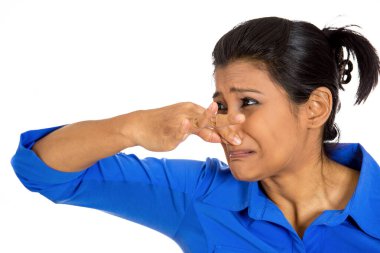 Burnunu kapatan genç bir kadının portresi, pis bir koku, beyaz arka planda izole edilmiş.. 