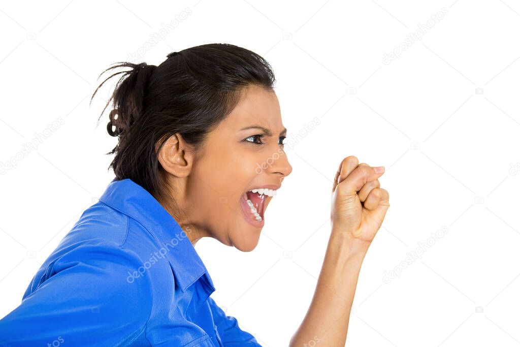 Closeup of an angry woman screaming with wide open mouth being hysterical