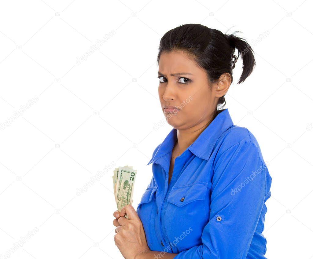 Portrait of greedy young woman corporate business employee holding dollar banknotes tightly, isolated on white background. 