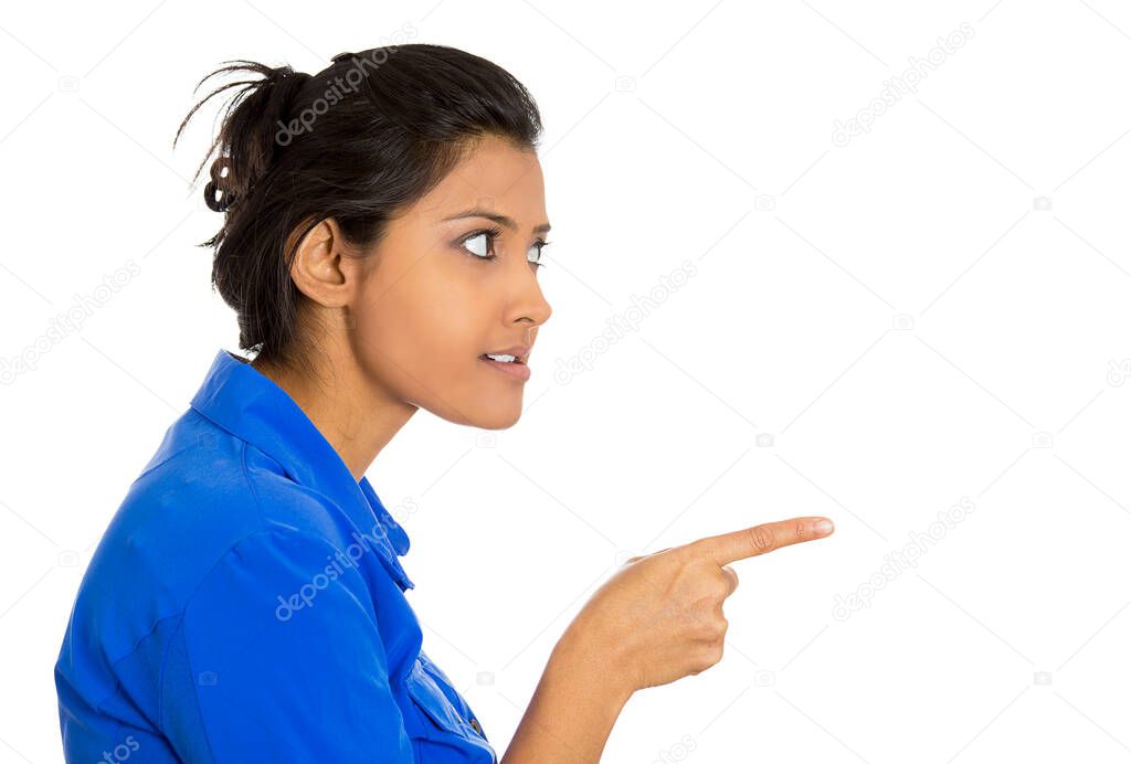 Side profile portrait of young unhappy, serious woman pointing at someone finger isolated on white background 