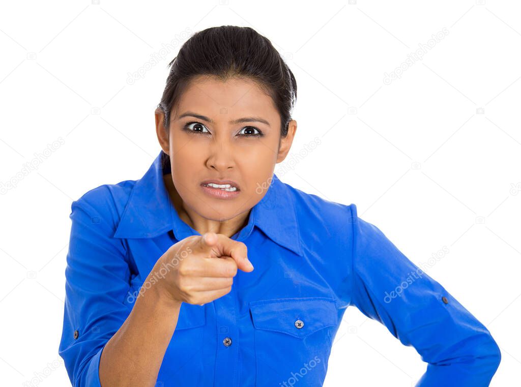 Portrait of young unhappy, serious woman pointing at someone finger isolated on white background 