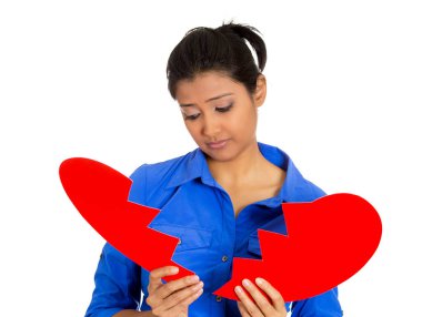 Genç üzgün, bunalımlı, kafası karışık bir kadının portresi. Kırık kalbini elinde tutan beyaz arka planda izole bir kadın.. 