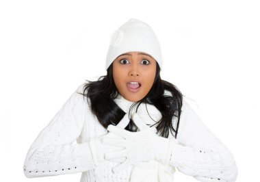 Yakından çekilmiş genç, güzel, şaşkın bir kadın portresi. Kış giysileri, eşarp, eldiven, süveter, beyaz arka planda izole edilmiş şapka giyiyor. Olumlu insani duygular, yüz ifadeleri, duygular, tutum