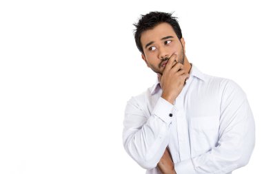 Genç bir adamın portresi beyaz arka planda elleri çenesinde izole edilmiş bir şey düşünüyor. 