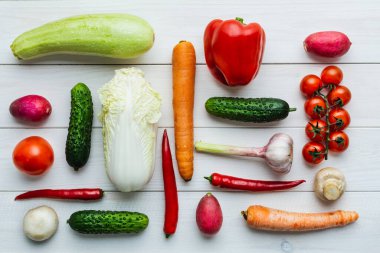 Çeşitli çiğ sebzeler. Knolling. Kabak, salatalık, biber, mantar, domates, karnabahar, kereviz, sarımsaklı kırmızı biber.