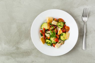 Beyaz bir tabakta gri bir arka planda Lübnan salatası Fattush. Sebzeler. Vejetaryenlik. Düz yatıyordu