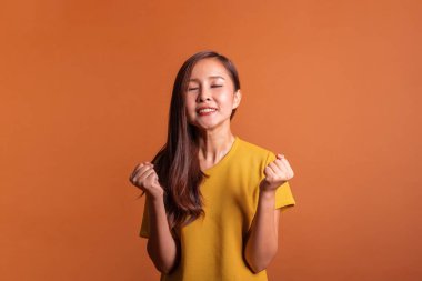 Kızgın Asyalı kadın turuncu arka planda, stüdyo çekimi