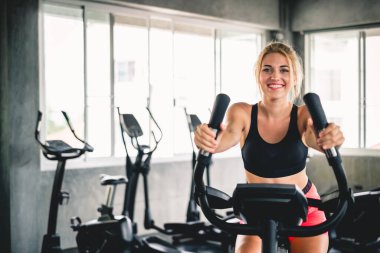 Spor salonunda kardiyo için bisiklet ve spor konseptiyle kadın antrenmanı.