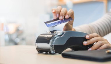 Müşteri, kafe restoranının sahibine ödeme yapmak için kredi kartı kullanıyor. Nakitsiz teknoloji ve kredi kartı ödeme kavramı.