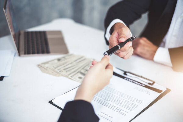 Businessman giving pen to businesswoman for signing contract banking money loaning