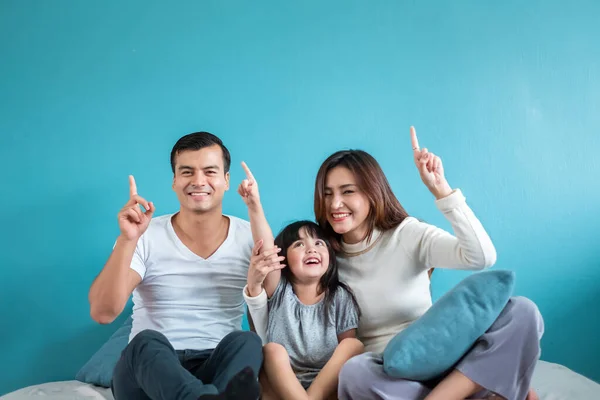 Mavi arka planda mutlu Asyalı aile portresi