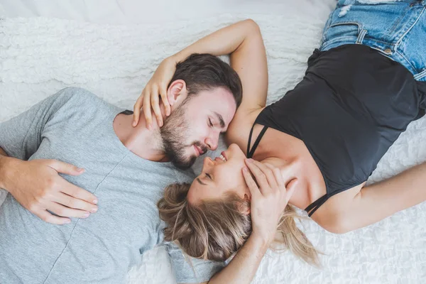 Mutlu çift yatakta, romantik zamanda sarılıp öpüşüyor, aşk ve tutkulu bir konsept..